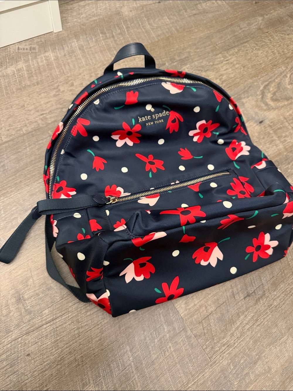 kate spade navy floral backpack with red and white accents